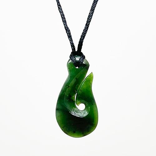 A gold-mounted New Zealand greenstone (nephrite jade) pendant on metal  chain.