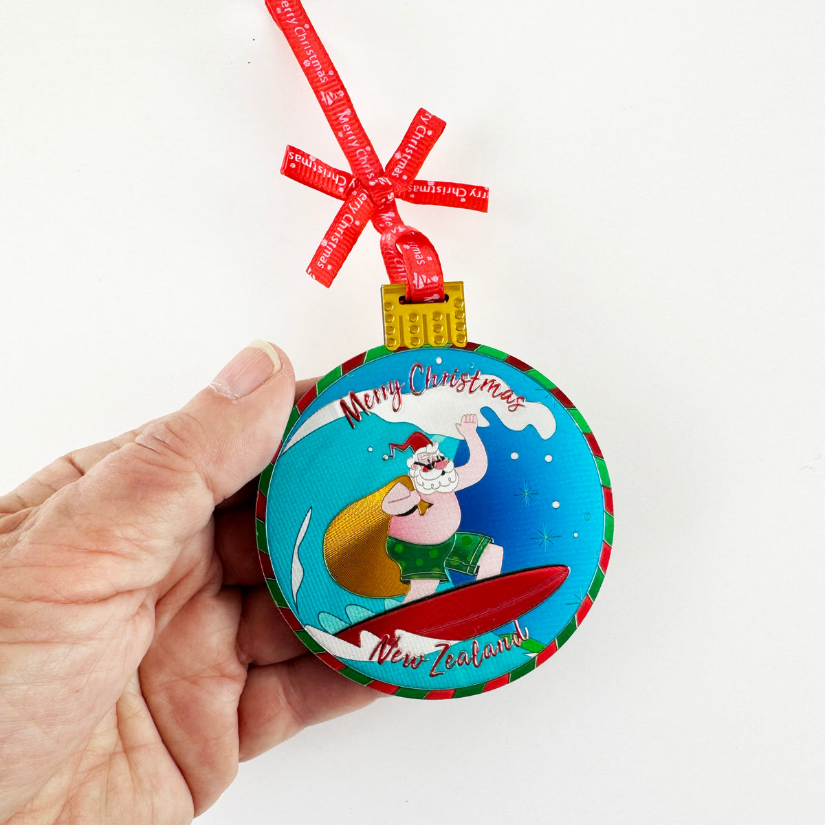 Shiny Foil NZ Santa on a Surfboard Christmas Ornament